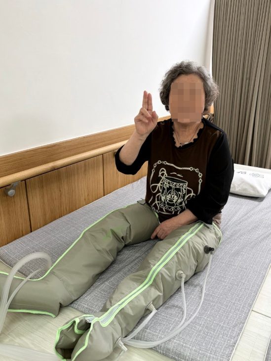 공기압 기구로 다리를 마사지하시는 어르신